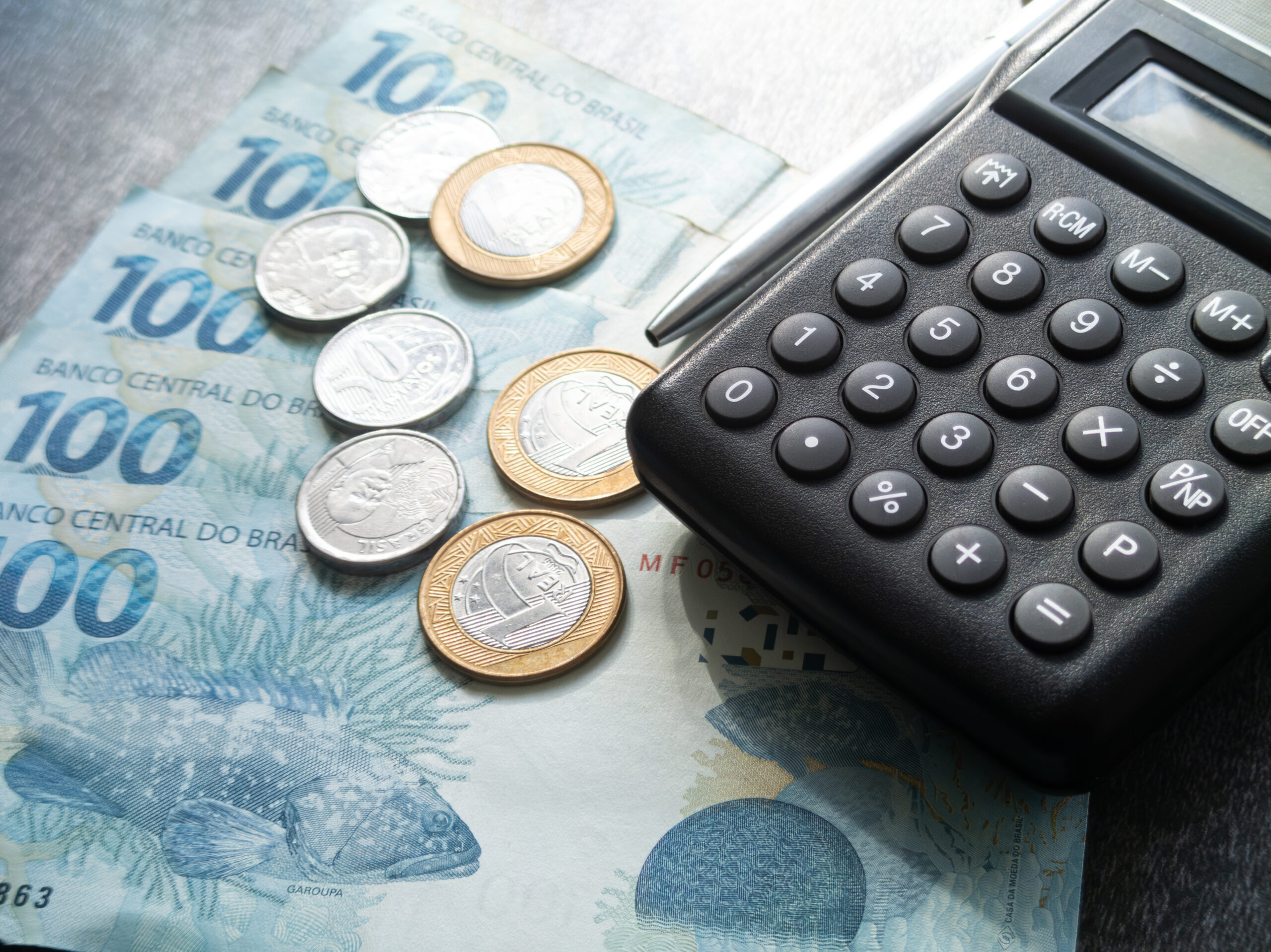 Finance concept one hundred reais bills and coins with calculato