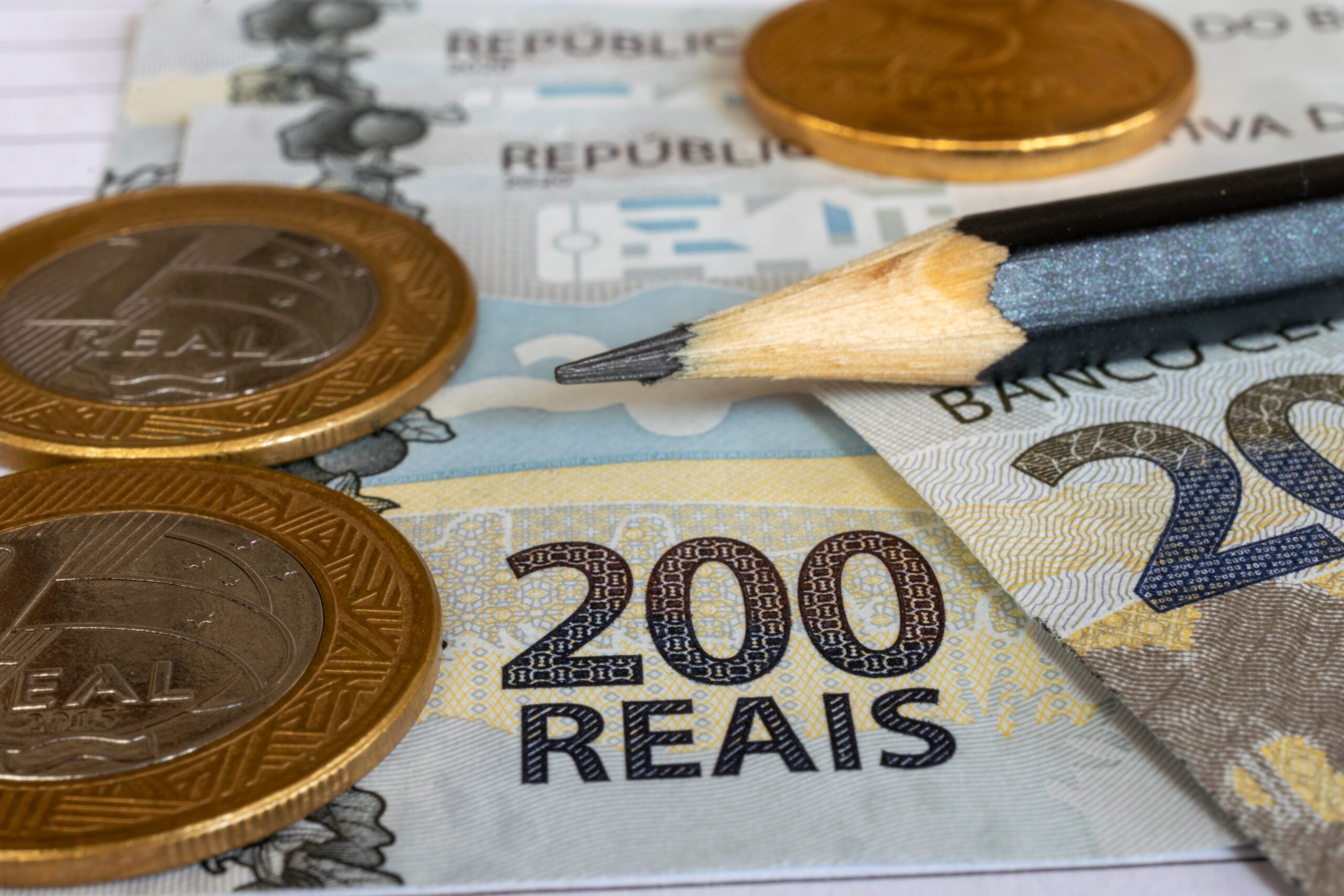 coins and banknotes of Brazilian money on the table. Selective focus.