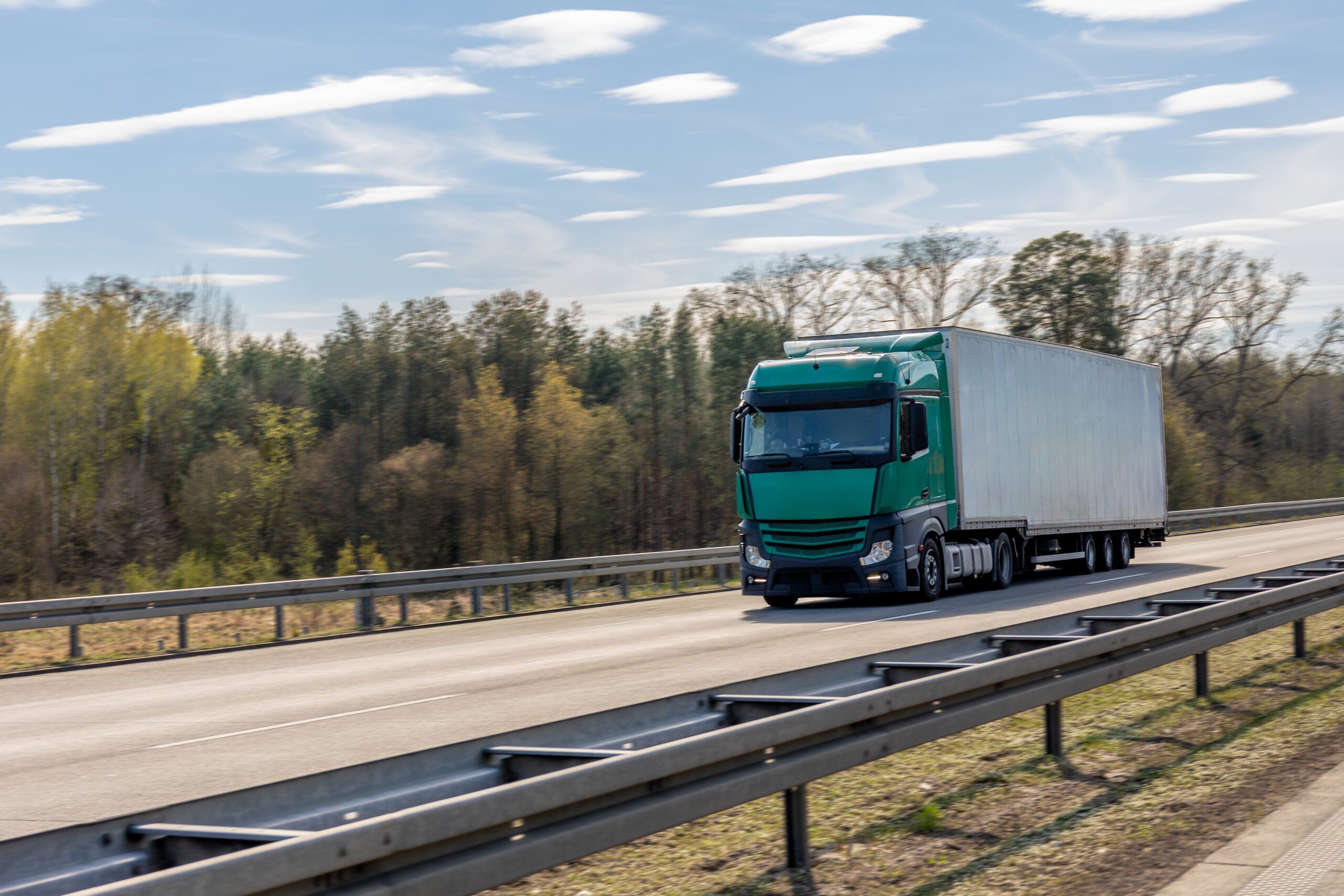 green-semi-truck-with-white-trailer-driving-highway-vehicle-moves-along-road