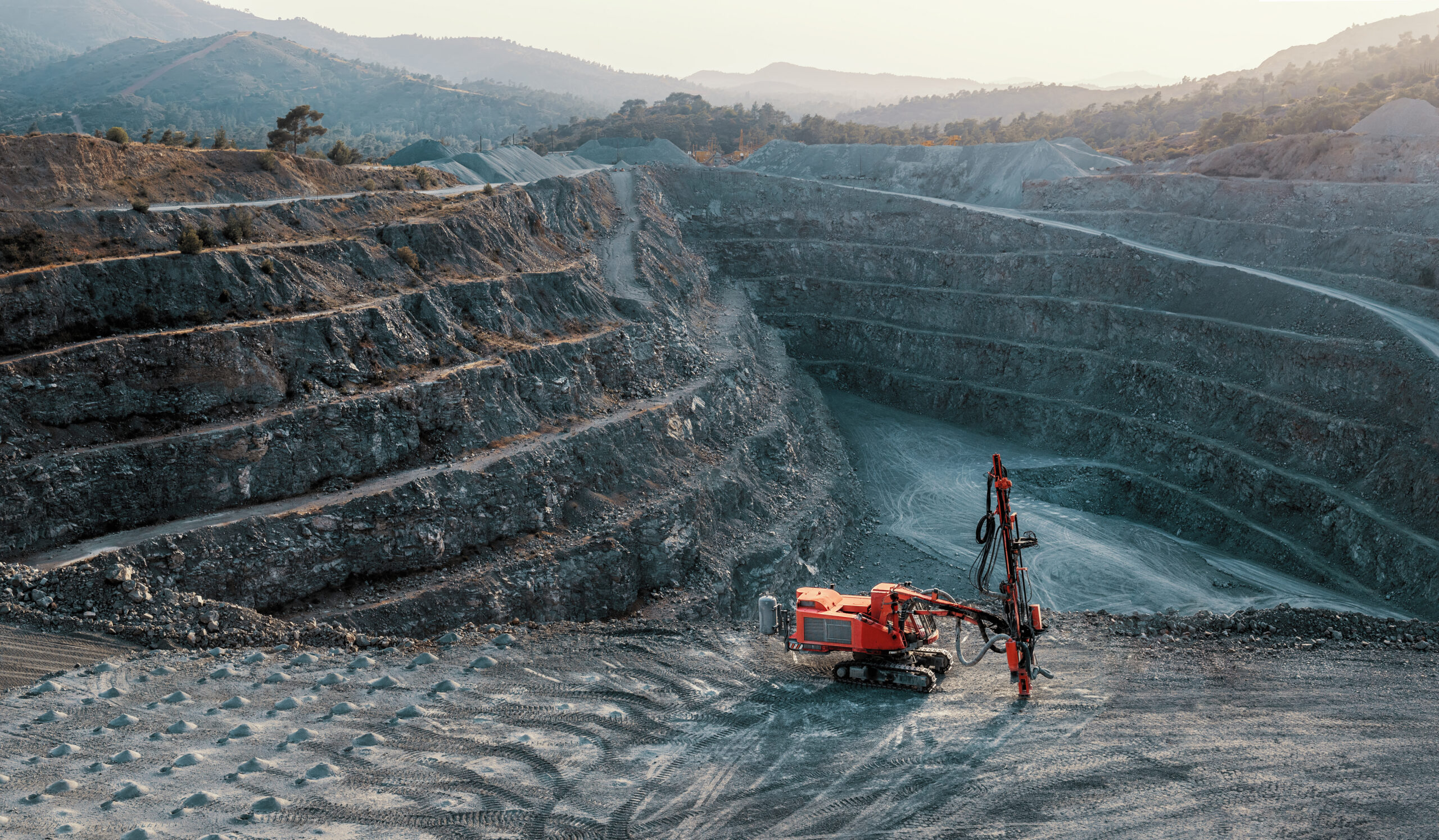 Red stone crusher on a terrace of gravel quarry. Industrial land